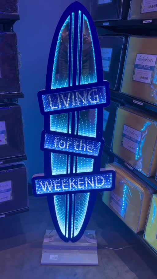 Owner-supplied showroom video screenshot of a blue illuminated surfboard-shaped Living for the Weekend display